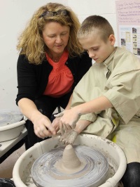 Mrs. McKinnon helps with ceramics project